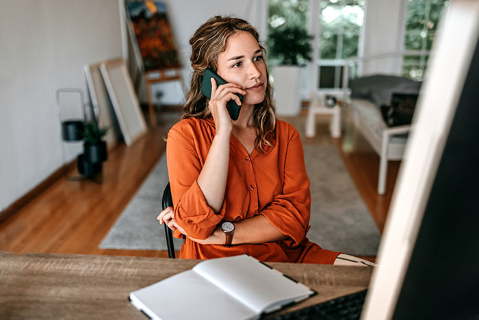 Woman talking on her phone in her home.