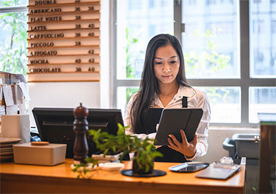 Woman standing behind a check out counter.
