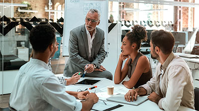 Workers sitting at a desk talking.