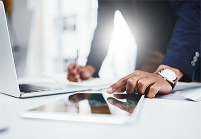 Man using tablet on a work surface.