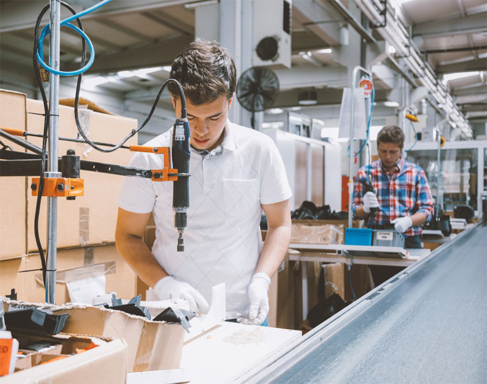 Young men working on an assembly line.
