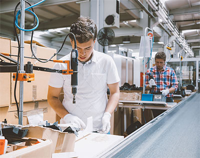 Young men working on an assembly line.