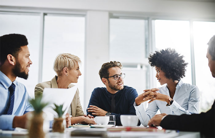 Five people having a business discussion at a table.