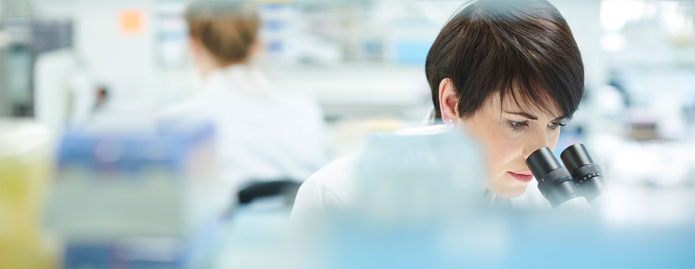 Female scientist looking into a microscope