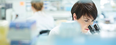 Female scientist looking into a microscope