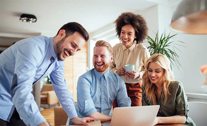 Four coworkers laughing.