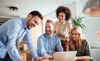 Four coworkers laughing.