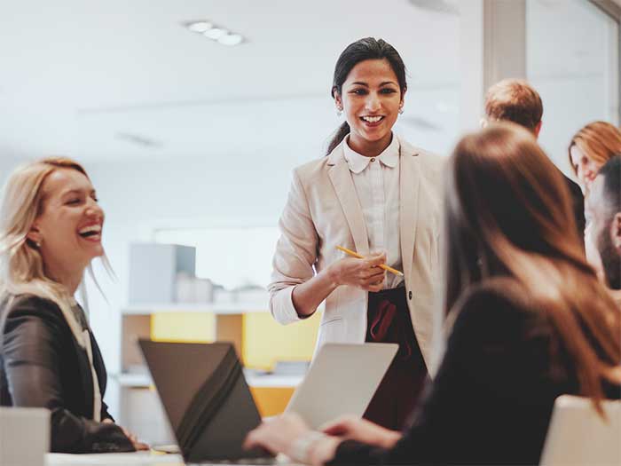 Several women talking before a meeting.