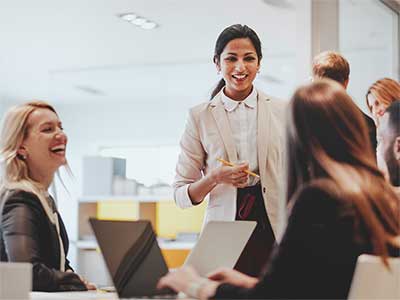Several women talking before a meeting.
