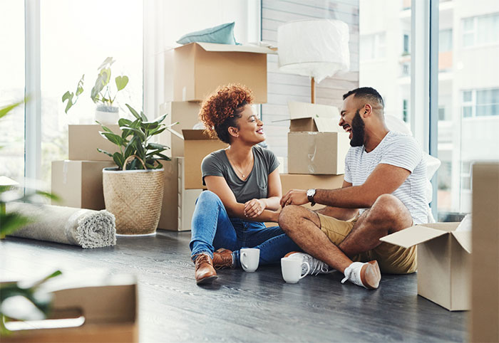 Young couple sitting on the floor of their new home.