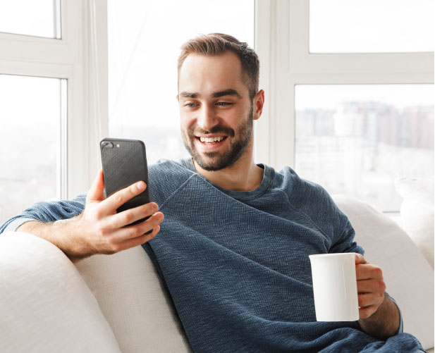 Man on couch checking his phone.