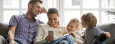 Family of four sitting on the couch.