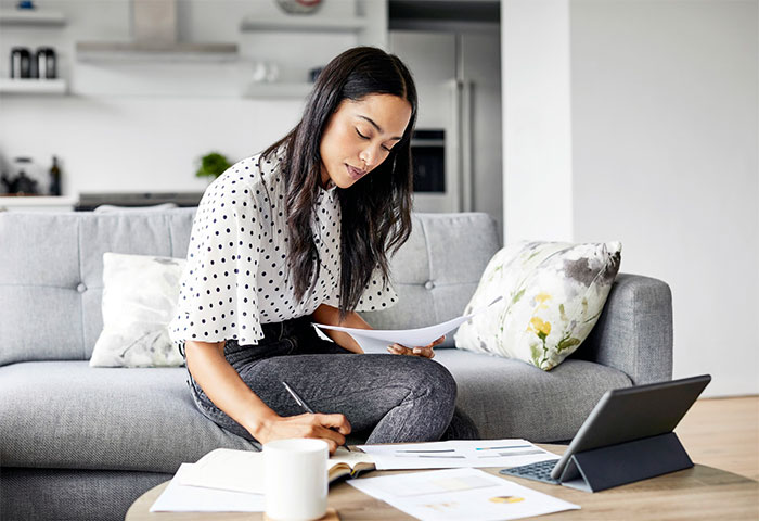 Woman on couch taking notes