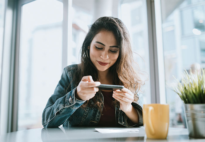 Smiling young woman looking at smartphone.