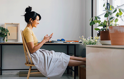 Woman at desk checking her phone
