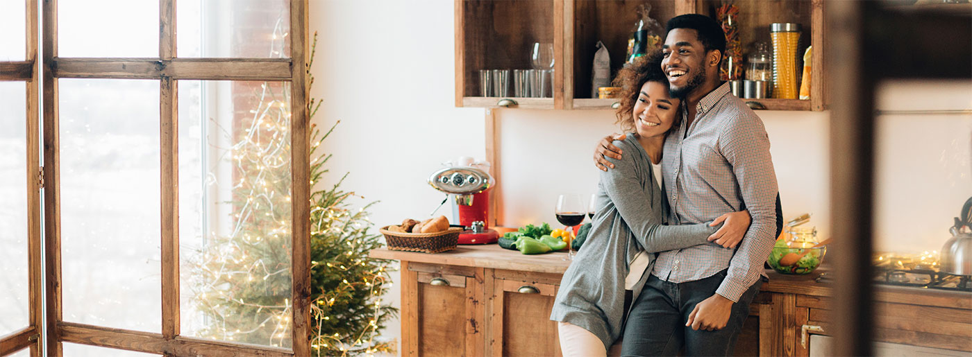 Couple hugging in their home.