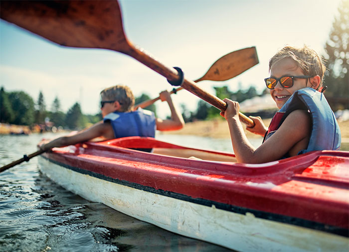 Two boys paddling in a canoe.