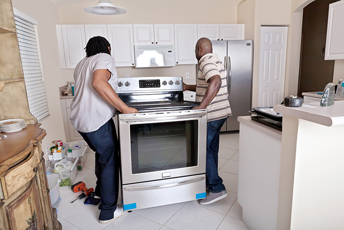 Couple of men installing a range