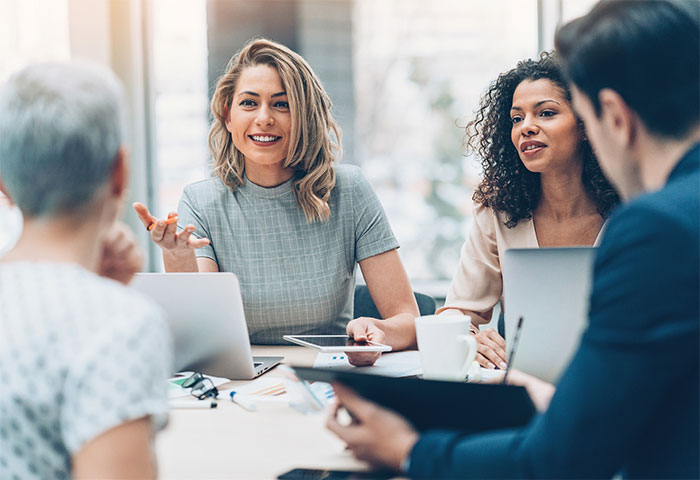 Four people in discussion at a meeting.