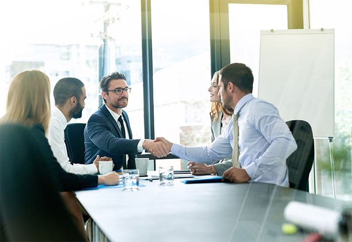 Businessmen shaking hands at a meeting.
