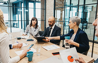 5 people in a conference room discussing institutional wealth.