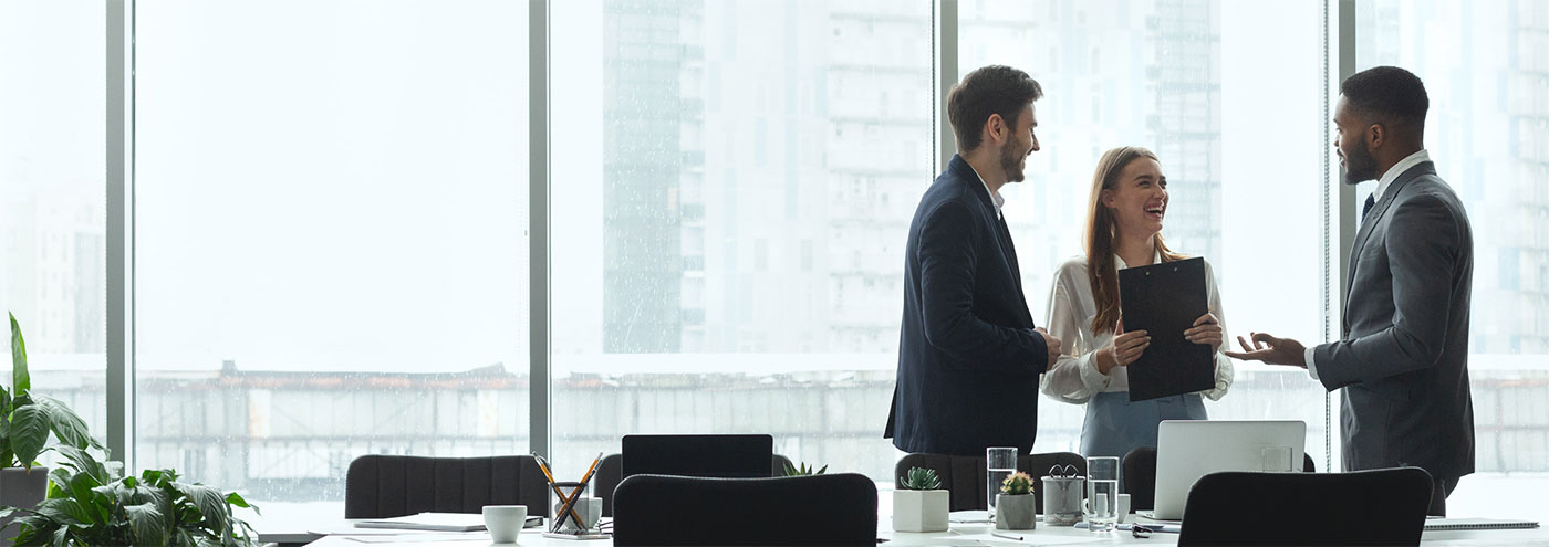 Three people in a boardroom.