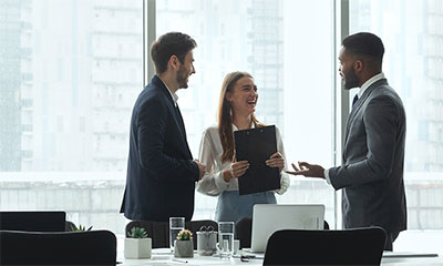 Three people in a boardroom.