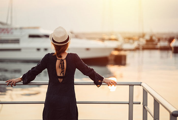 Woman on dock looking at large boat.