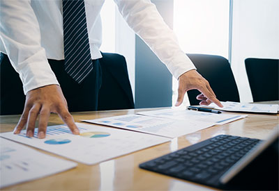 Man standing at desk, looking over figures