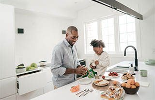Father and daughter in kitchen cooking