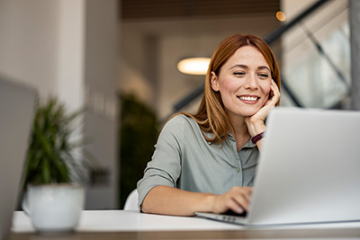woman smiling at her laptop