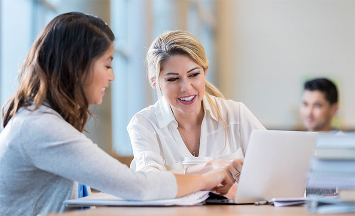 Two women looking at a laptop.