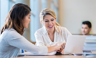 Two women looking at a laptop.